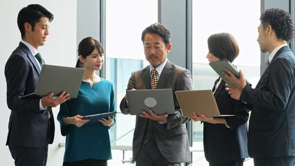 Fototapete - デジタルデバイスを持って打ち合わせするビジネスパーソンのグループ