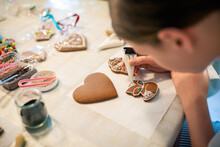 Close-up Of A Young Girl Decorating Gingerbread Cookies With Icing.