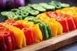 colorful bell peppers sliced and displayed in a row