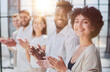 © Katsiaryna - Group of businesspeople sitting in a line and applauding.