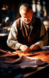 © Elena Uve - Artisan man working with leather. Closeup photo showing the process of making leather goods.