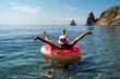 © svetograph - Summer vacation woman in hat floats on an inflatable donut mattress. Happy woman relaxing and enjoying family summer travel holidays travel on the sea.