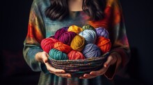 A Young Woman Holds A Stylish Black Wire Basket In Her Arms. Balls And Skeins Of Bright Colored And Beautiful Yarn For Knitting. Hobbies Knitting And Crocheting.