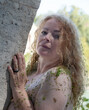 portrait of a beautiful, seductive, sexy mature Woman after bath in Tiber leaning against bridge pier with duckweed in wet hair