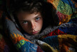 Close-up portrait of a boy wrapped in a blanket