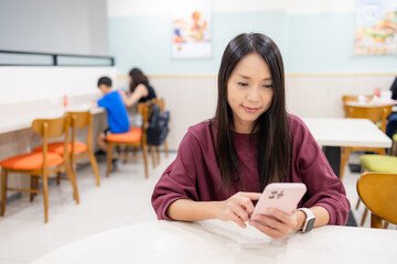 Poster - Woman look at the cellphone in restaurant