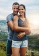 © C Pendl/peopleimages.com - Portrait, hug and couple with happiness, outdoor and lens flare with holiday, romance and vacation. Face, man and woman with bonding, adventure and health with fun, outside and wellness with love
