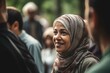A Muslim woman engaging with local residents at a community gathering, listening to their concerns and ideas, and actively participating in discussions. Community involvement and building connections.