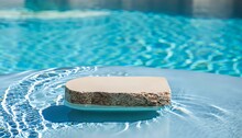 Stone Podium Stand In Luxury Blue Pool Water. Summer Background Of Tropical Design Product Placement Display