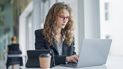 Poster - Young woman business worker using laptop and touchpad working at the office