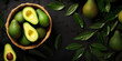 Top view of a cluster of avocados in a wooden basket on a green leaf background.