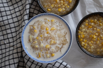 A bowl of homemade corn and sticky rice dessert with a drizzle of coconut milk.  