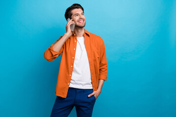 Wall Mural - Portrait of cheerful successful young man speak communicate colleagues telephone isolated on blue color background