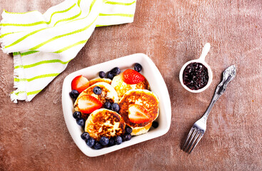 Canvas Print - Cottage cheese pancakes with raspberries and blueberry on light background, breakfast or lunch