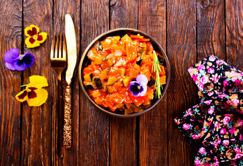 Wall Mural - vegetable stew, eggplant, onion, zucchini with tomato sauce, garlic and herbs in a baking dish on a wooden table, landscape view from above, close-up, flat lay, free space