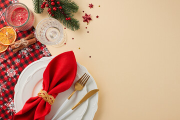 The perfect blend of style and festivity on the Christmas table. Top view photo of plates, cutlery, tablecloth, glass, dry orange slices, glass, spruce twig, confetti on beige background with ad area