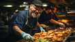
Fast food restaurant worker cooking hamburgers in the restaurant's kitchen. Middle-aged man with tattoos and gray hair working happily in a junk food restaurant. Person cooking hamburgers. Copy space