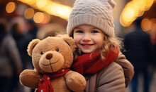 A Girl Toddler Smiling And Holding A Brown Teddy Bear