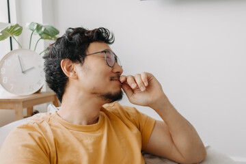 Wall Mural - Laugh and shy asian man in yellow t-shirt on bean bag. Charming and relaxing.