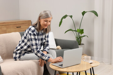 Poster - Beautiful senior woman using laptop at home