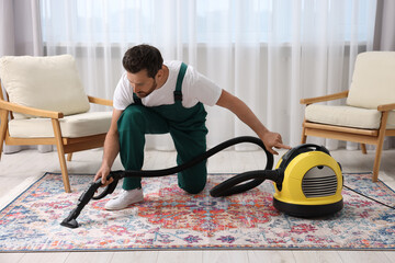 Wall Mural - Dry cleaner's employee hoovering carpet with vacuum cleaner in room