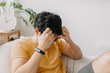 © Sevendeman - Laugh and shy asian man in yellow t-shirt on bean bag. Charming and relaxing.