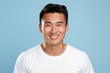 © Tuyres - Portrait of a Happy Fictional Handsome Asian Male Model Smiling Candidly. Isolated on a Plain Colored Background. Generative AI.