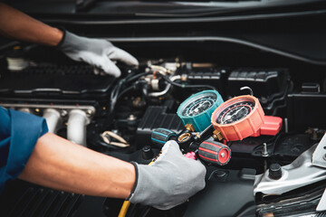 Car care maintenance and service, Hand technician auto mechanic using measuring manifold gauge check refrigerant and filling car air conditioner to fix repairing heat conditioning system.