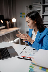 Asian woman is in office of a startup company, young businesswoman is giving a presentation via online video call to group of company executives, presenting a management budget. Online meeting ideas.