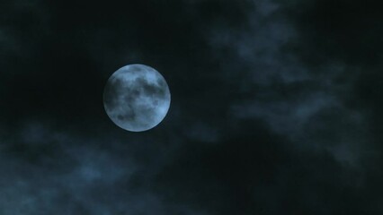 Wall Mural - full moon in the sky with clouds at night. the moon hangs motionless while black clouds fly past it.