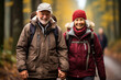 © Valeriia - Romantic elderly healthy lifestyle concept. Senior cheerful active smiling mature couple walks looks happy in the park with hiking modern backpacks, in afternoon autumn day, happily retired
