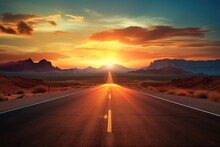 The Sun Is Setting Over A Road In The Middle Of The Desert, With A Line Of Cars Driving Down The Middle Of The Road. A Road At Sunset