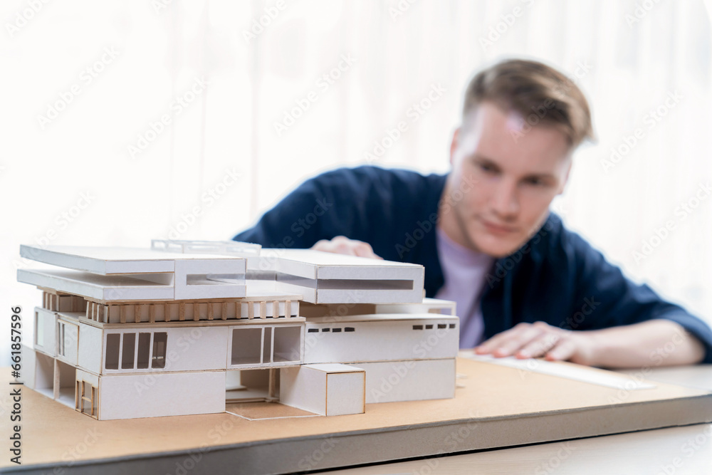 Architect designer studies elegant house model, reviewing structure ...