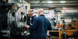 © Stavros - Male workers checks quality of mechanisms at a large machine-building enterprise. Mechanical engineering, as one of the most important components of independence of the country's economy.