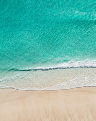 Wall Mural - Aerial view of a stunning beach and white sand near the ocean with gentle wave