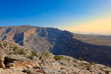 Fototapeta Miasto - Terrace over the canyon of Wadi Ghul rocky mountain lit by the morning sun. Oman.
