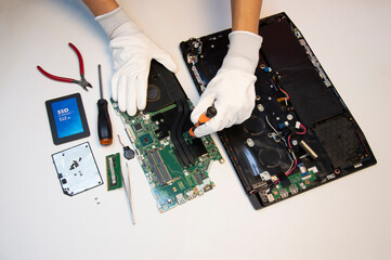 Wall Mural - Top view. Technician repairing notebook computer, repairing motherboard and circuit.