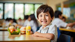Young boy preschooler sitting in the school cafeteria eating lunch.