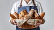 Boulanger en tenue présente les pains de sa boulangerie dans un panier
