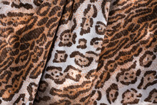 Wavy Textured Fabric With Leopard Or Cheetah Print, Close Up. The Fabric Is Made As An Imitation Of Skin Of A Wild Leopard