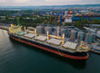 Aerial view of big cargo ship bulk carrier in the port at sunset