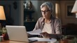 © mattegg - Photo of a woman working at a desk with a laptop and papers