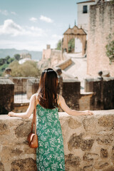 Wall Mural - A woman standing on the cliff edge, looking at the historic buildings in Ronda, Spain