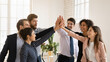 © fizkes - Cheerful multiethnic team of young professionals giving group high five, enjoying teamwork spirit, celebrating job success, achievement, win, successful cooperation, shouting for joy