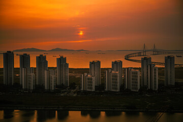 Wall Mural - Incheon City Harbor skyline at overcasting sunrise with a view of the curving Incheon Bridge linking Yeongjong Island with the mainland in South Korea