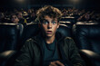 Scared teen watches horror movie in cinema, face of shocked boy