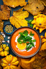 Wall Mural - Sweet autumn pumpkin soup with cream, tangerine and mint. Winter healthy vegetarian comfort slow food. Soup bowl on green table background. Top view