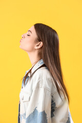 Sticker - Young woman blowing kiss on yellow background