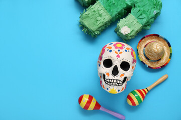 Sticker - Painted human skull for Mexico's Day of the Dead (El Dia de Muertos), maracas, sombrero and pinata on blue background