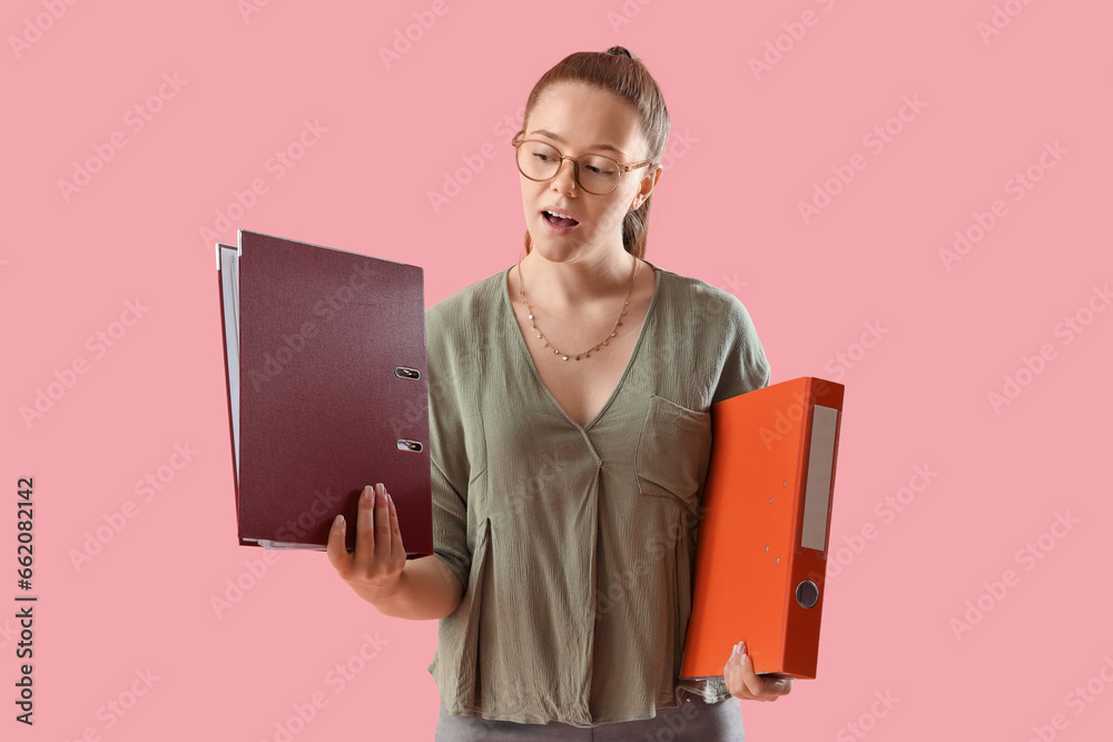 Young woman with document folders on pink background